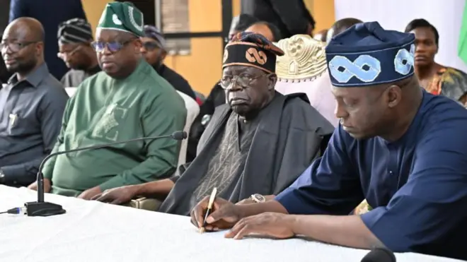 Bola Tinubu wear black attire and brown cap