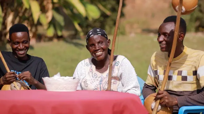 Umuhanzi Ruth Nyirampfumukoye uzwi nka Sure Mwana hamwe n'abahungu be nabo b'abahanzi baseka mu byishimo