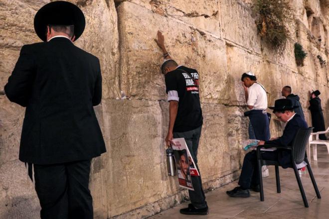A man touches the Western Wall, the holiest site where Jews are allowed to pray, in the old city of Jerusalem