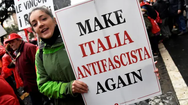 Personas con pancartas con mensajes antifascistas mientras participan en una marcha convocada por los partidos y organizaciones de izquierda italianos en el centro de Roma el 24 de febrero de 2018, una semana antes de las elecciones generales de Italia. 