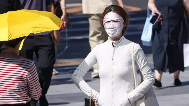 2026年5月30日，中国北京天气炎热，一名居民遮住脸部防晒。北京当日录得2026年首个高温日，气温达摄氏35度。