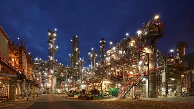 Погон рафинерије ноћу, обасјан рефлекторима