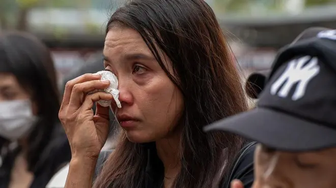  Hong Kong'ta yapılan anma töreninde bir kadın gözyaşlarını mendille siliyor. Ağlamaktan gözleri kızarmış bir durumda