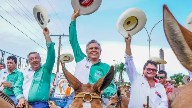 Ronaldo Caiado acena com chapéu de vaqueiro em cima de cavalo ao lado de apoiadores