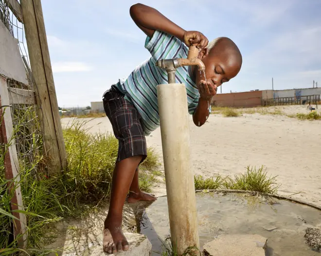 ታዳጊ ልጅ ውሃ እየጠጣ