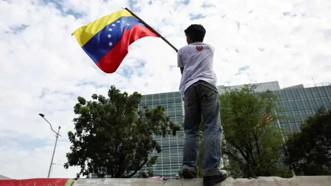 A person waves a Venezuelan flag