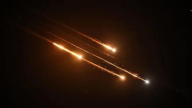 Падающие обломки сбитых иранских ракет в ночном небе