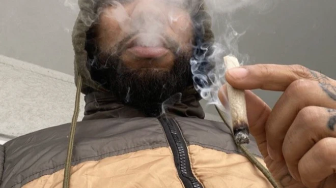 man smoking an illegal cigarette