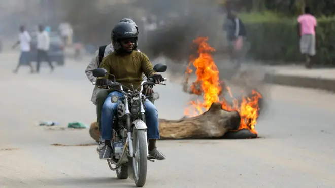 Pipo on top motorbike drive past one tree stump set wey dey burn for Luanda on Monday.