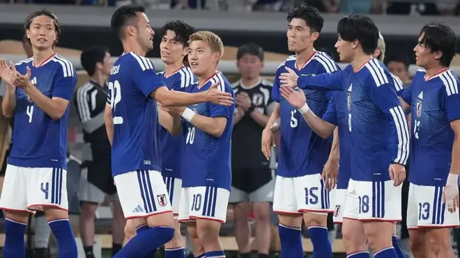 青いユニホームを着た日本代表選手らが集まり声を掛け合っている