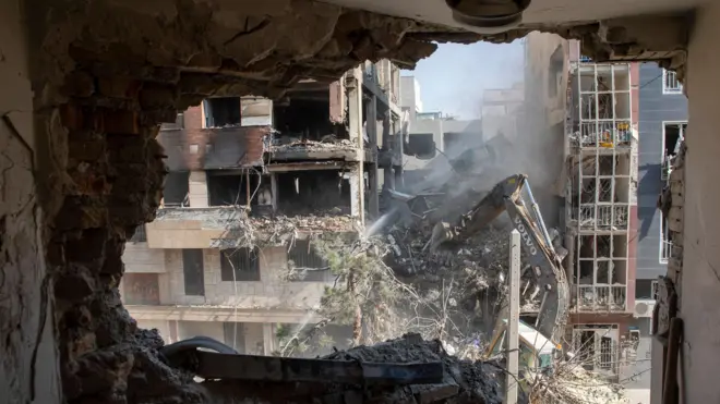 مشهد من غرفة معيشة مبنى سكني في طهران دُمّر في هجوم إسرائيلي في 13 يونيو/حزيران 2025 في إيران.