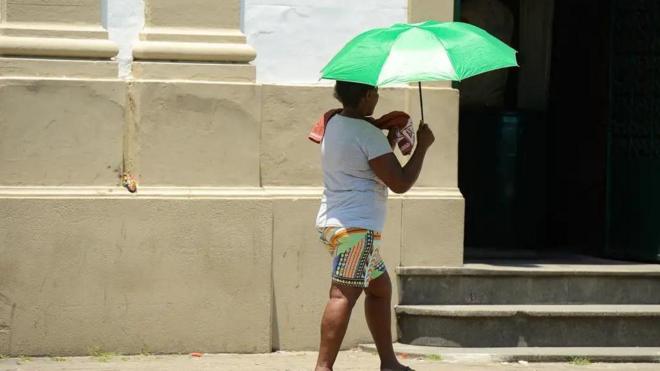 Mulher se protege do calor no Riocalculadora apostas desportivasJaneiro