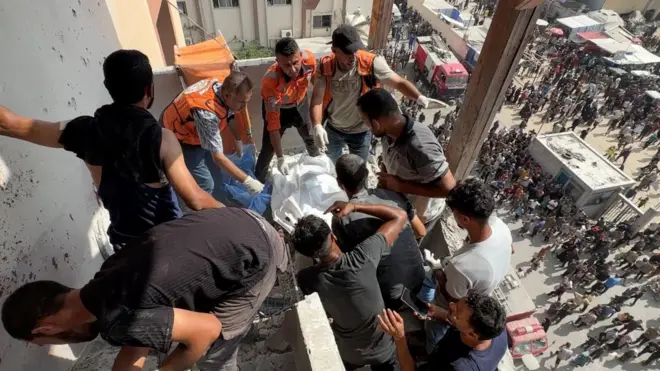 Miembros de equipos de rescate y otras personas se aglomeran en una terraza del hospital Nasser en Gaza.