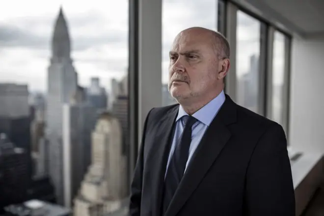 Feridun Sinirlioğlu, New York'ta bir camın önünde duruyor.