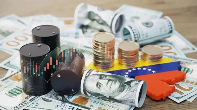 مقداری اسکناس و سکه در کنار پرچم ونزوئلا و چند بشکه نفت