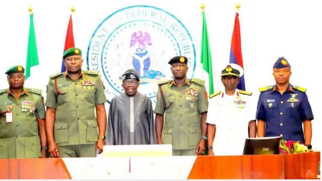 Àwọn ọ̀gá illese ológun dúró ní apá àti apa òsì ààrẹ Bola Ahmed Tinubu.