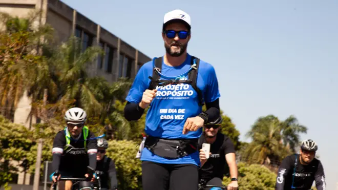 هوغو فارياس يرتدي قميصاً أزرق ونظارة شمسية وقبعة، ويتبعه ثلاثة يركبون على دراجات
