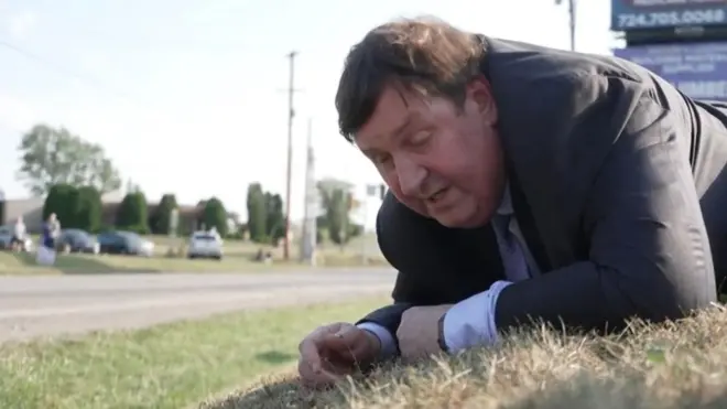 Gary O'Donoghue, tumbado en el piso, transmitiendo desde el mitin en el que hirieron a Donald Trump.