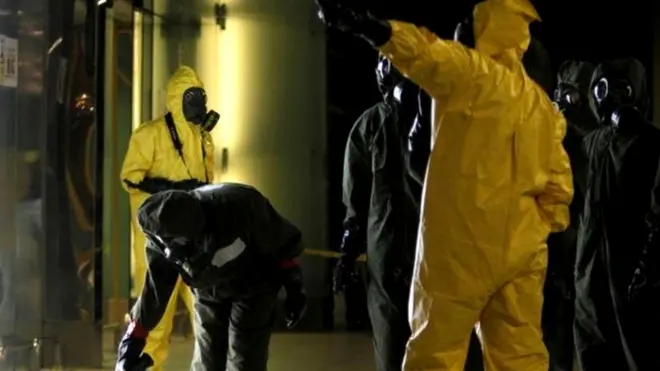 रसायन की जांच करते सुरक्षाकर्मी