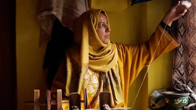 Женщина прядет пряжу