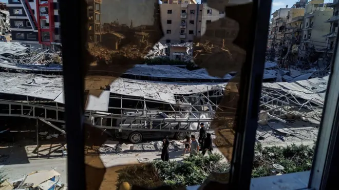 يمرّ الناس بجوار الأنقاض في موقع غارة إسرائيلية أعقبت اتفاقاً بين الولايات المتحدة وإيران في صور، جنوب لبنان، 16 يونيو/حزيران 2026.