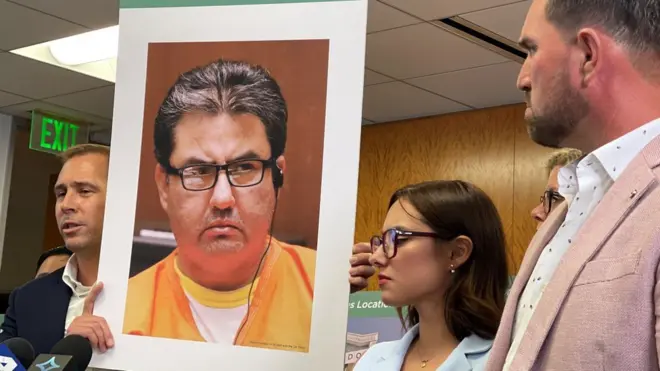 El abogado Mike Rick sostiene un cartel con la cara de Naasón Joaquín García junto a Sochil Martin y Sharim Guzmán.