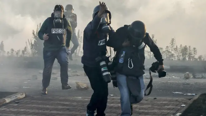 Journalists with tear gas masks at protest in West Bank