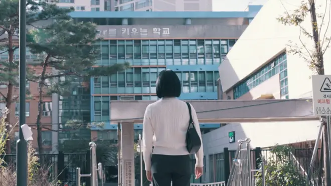 학교 앞에 서 있는 여성의 뒷모습