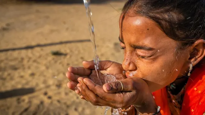 Una joven india bebe agua fresca en un pueblo del desierto de Thar, Rajastán.