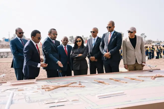 ጠቅላይ ሚኒስትር ዐቢይ ከሌሎች ከፍተኛ ባለሥልጣናት ጋር በመሆን የመሰረት ድንጋይ ከማስቀመጣቸው በፊት የፕሮጀክቱን ዲዛይን ሲጎበኙ