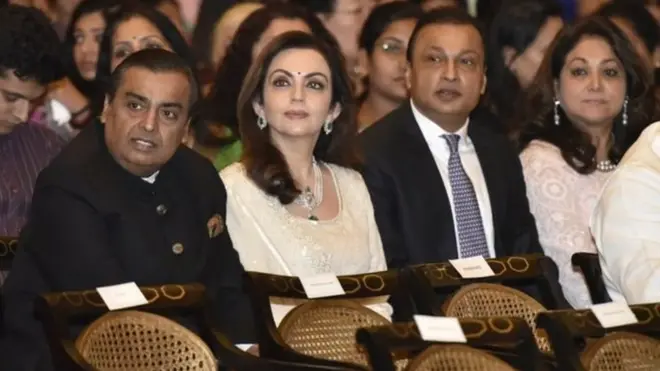 Mukesh Ambani, oo dhanka bidix jira ayaa la fadhiya xaaskiisa Ambani, waxaana dhanka midig ka fadhiya walaalkiis Anil Ambani