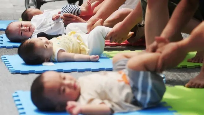 Three babies lying on mats