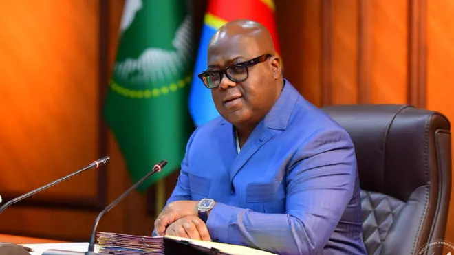 Perezida Félix Tshisekedi yicaye mu ntebe yambaye isuti (ikositimu) y'ubururu. 