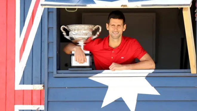 Novak Djokovic holding the 2021 Australian Open championship trophy, February 2021