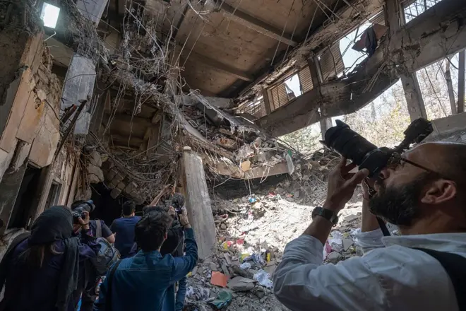 عکاسان در حال تصویربرداری از ساختمان اداری زندان اوین که بر اثر حملات اسرائیل تخریب شد