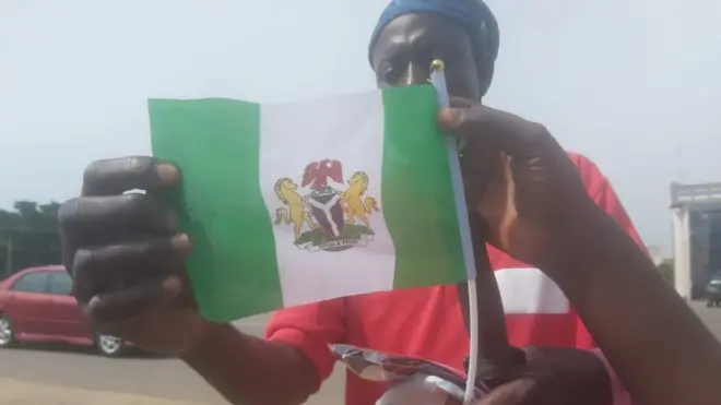 One man dey hold Nigerian Flag for Abuja