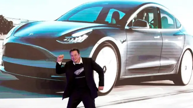 ماسك وخلفه سيارة كهربائية