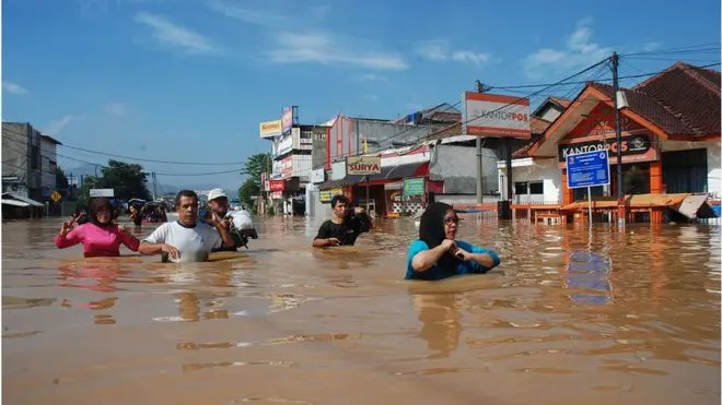 Sejumlah warga Bandung berjalan di tengah banjir, pada 2016 lalu. Agar bisa menjadi bagian dari solusi mengatasi banjir dan genangan air di jalan, sebuah material berpori diciptakan seorang dosen ITB.
