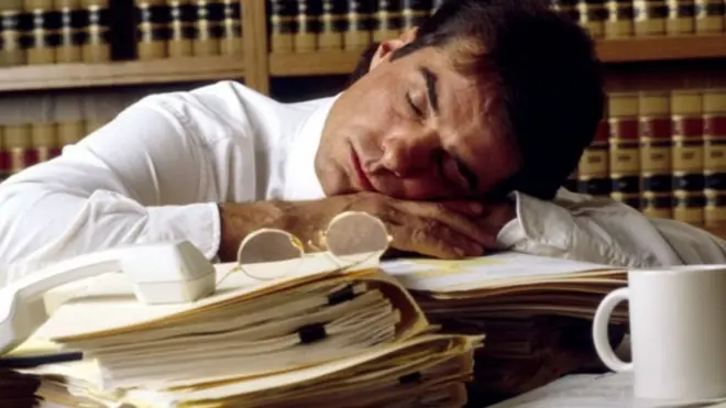 موظف نائم على مكتبه أثناء العمل