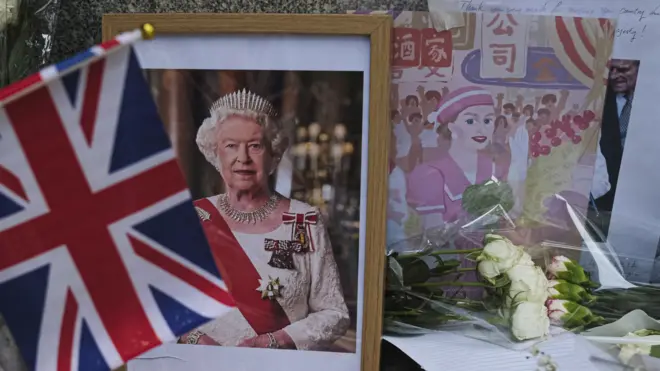 香港英國領事館外民眾擺放英女王伊麗莎白二世遺像與紀念她1975年訪問香港的繪畫(10/9/2022)