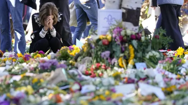 امرأة تكرّم الملكة الراحلة في حديقة هايد بارك قبل أيام من موعد الجنازة