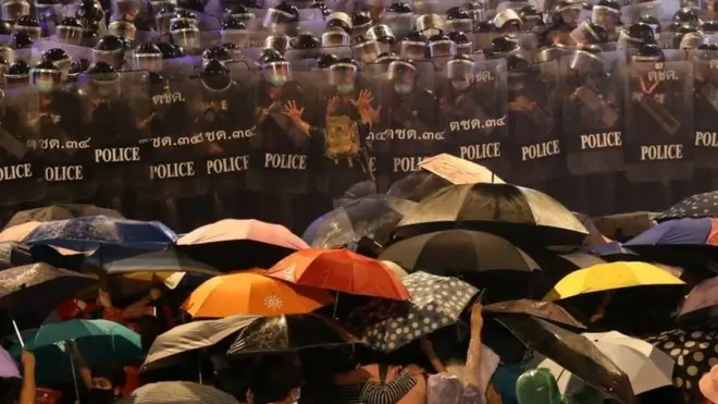 Pro-democracy protesters face riot police during an anti-government protest in Bangkok, Thailand, 16 October 2020