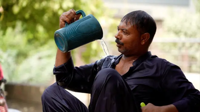 더위를 식히기 위해 몸에 물을 끼얹고 있는 파키스탄 남성