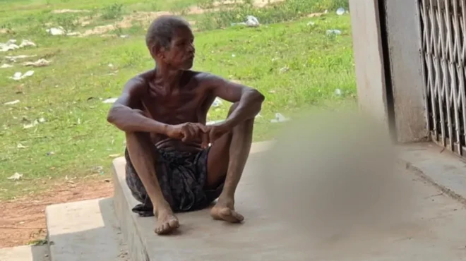  جیتو موندا که در این تصویر در کنار در ورودی بانک، در ایالت اودیشا در شرق هند نشسته، گفته است که پس از ناکامی در برداشت پس‌انداز خواهرش از بانک، مجبور شد برای اثبات مرگ او بقایای اسکلتش را به بانک ببرد 