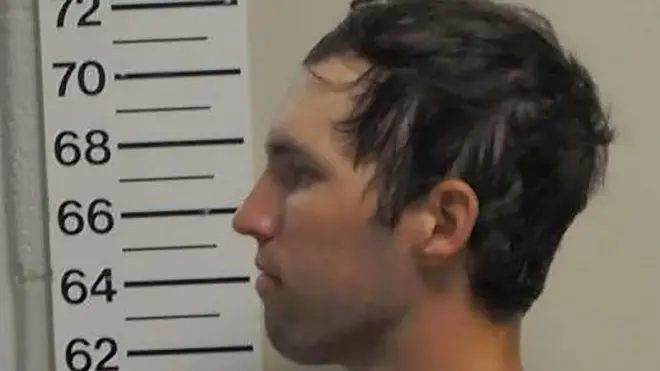 Perfil de Tyler Robinson mirando hacia la izquierda, donde hay un metro para medir la estatura.