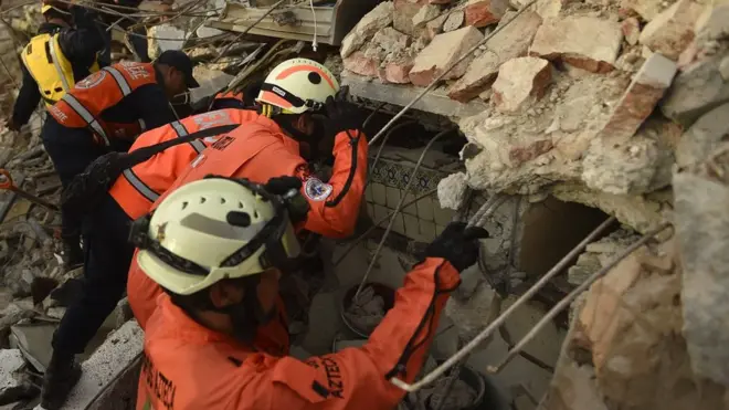 Tim penyelamat berusaha menemukan korban yang kemungkinan masih terperangkap di reruntuhan gedung di Kota Juchitan de Zaragoza, Mexico, 9 September 2017.