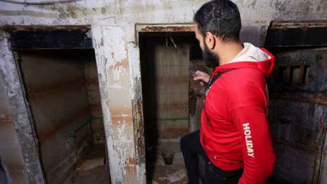Mohammed Hanania, de 35 años y exprisionero sirio de Damasco, mira junto a los baños en una prisión subterránea que fue operada por la inteligencia militar siria.