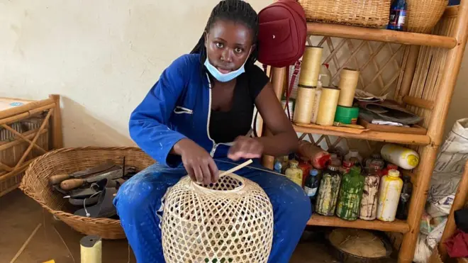 Denise Igirimbabazi ari gukora agakoresho kabikwamo ibintu gakoze mu migano