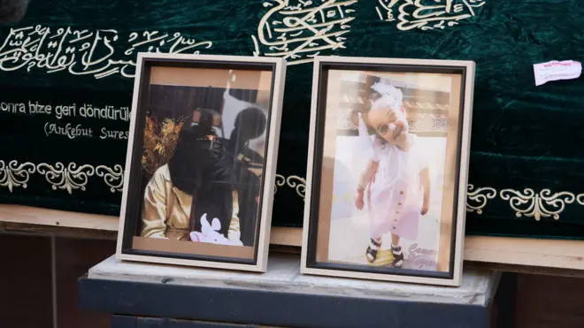 Bir tabutun önünde, İstanbul'da Zeytinburnu sahilinde ölü bulunan Fatmanur Çelik ve kızının yan yana fotoğraflarının yer alıyor. 