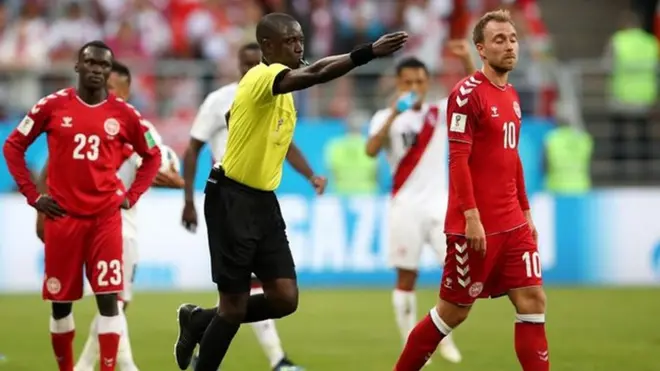 Trọng tài Bakary Gassama (áo vàng) có tình huống "cắt còi" trong trận đấu giữa Đan Mạch và Peru sau khi tham khảo VAR